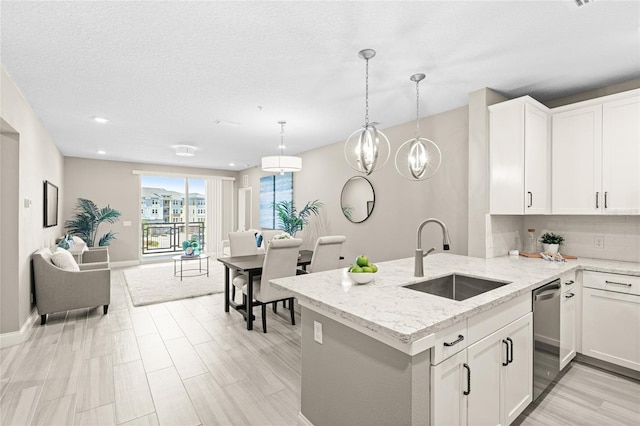 7573 Laureate Blvd Unit 1301, Orlando, FL 32827 - kitchen featuring a sink, stainless steel dishwasher, light stone countertops, tasteful backsplash, and white cabinetry