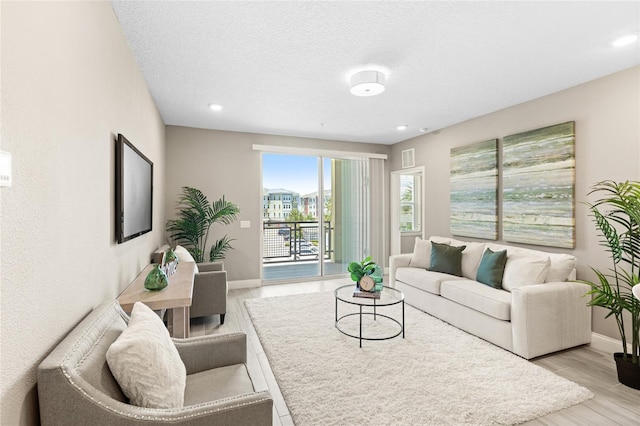 7573 Laureate Blvd Unit 1301, Orlando, FL 32827 - living room with baseboards, recessed lighting, light wood-style flooring, and a textured ceiling