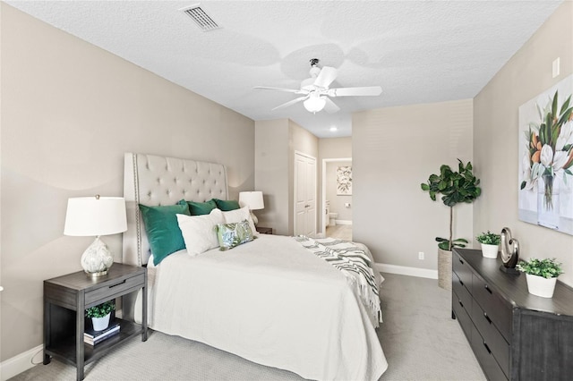 7573 Laureate Blvd Unit 1301, Orlando, FL 32827 - bedroom with light colored carpet, baseboards, ensuite bathroom, a ceiling fan, and a textured ceiling