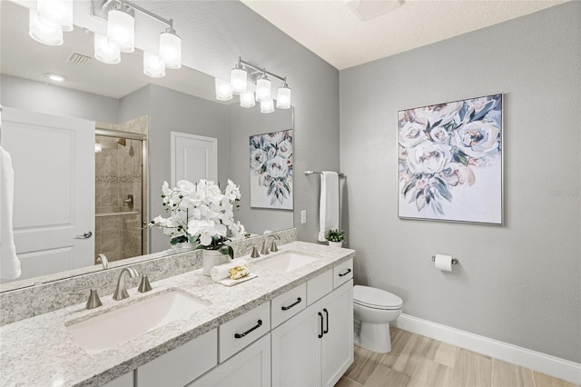 7573 Laureate Blvd Unit 1301, Orlando, FL 32827 - bathroom featuring a shower stall, baseboards, toilet, double vanity, and wood finished floors