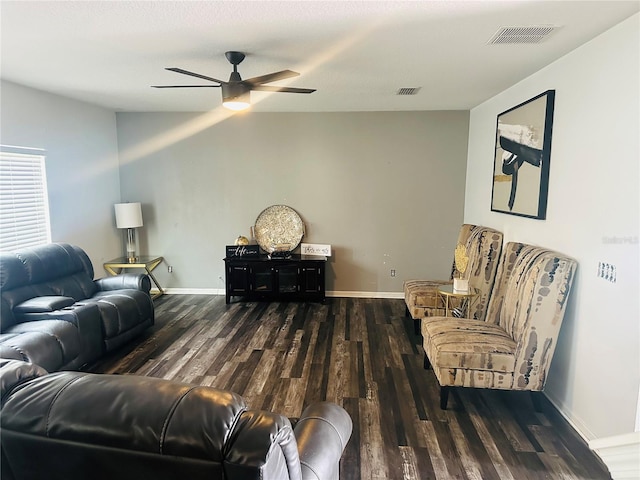 living room with ceiling fan and dark wood-type flooring