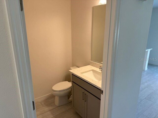 bathroom featuring hardwood / wood-style floors, toilet, and vanity