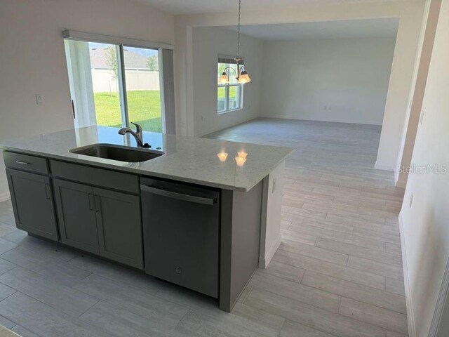 kitchen with plenty of natural light, a kitchen island with sink, and dishwasher