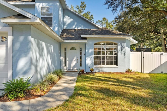 view of exterior entry with a yard