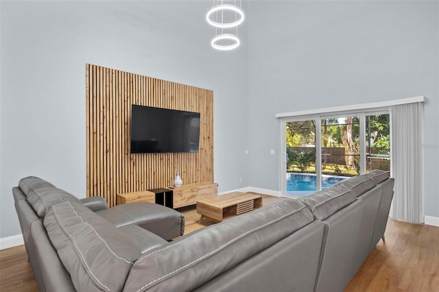 living room with wood-type flooring and a towering ceiling