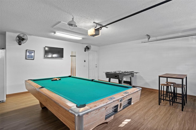 recreation room featuring pool table, a textured ceiling, and hardwood / wood-style flooring