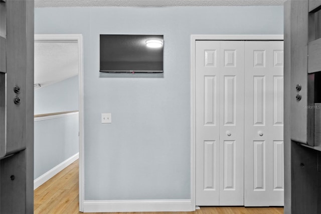 bedroom featuring a textured ceiling, light wood-type flooring, and a closet