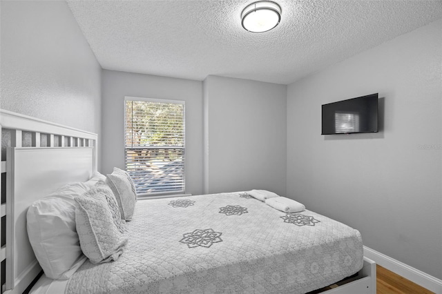 bedroom featuring hardwood / wood-style floors and a textured ceiling