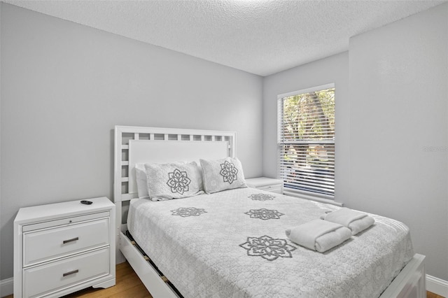 bedroom featuring a textured ceiling and light wood-type flooring