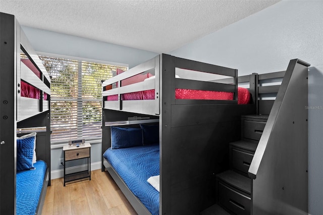 bedroom with a textured ceiling and light wood-type flooring