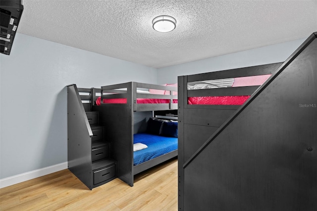 bedroom featuring hardwood / wood-style floors and a textured ceiling