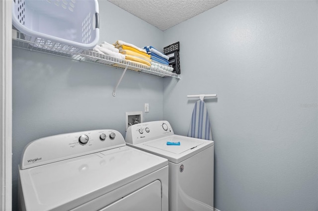 laundry room with independent washer and dryer and a textured ceiling