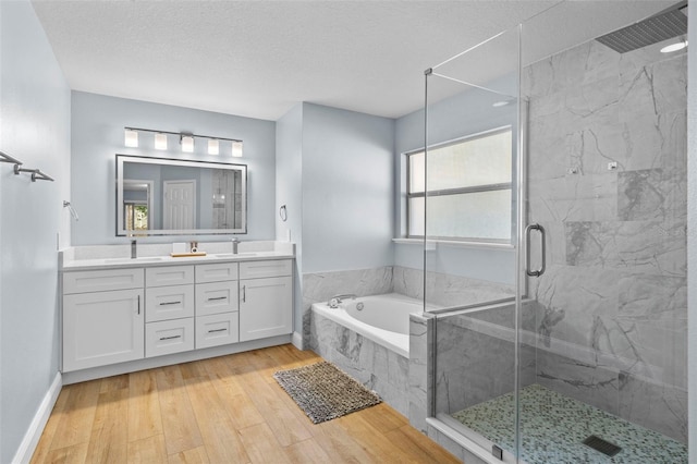 bathroom featuring hardwood / wood-style floors, a healthy amount of sunlight, a textured ceiling, and plus walk in shower