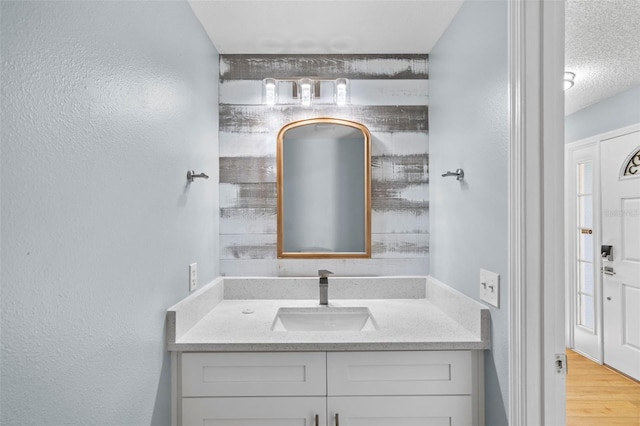 bathroom featuring a textured ceiling, vanity, and hardwood / wood-style flooring