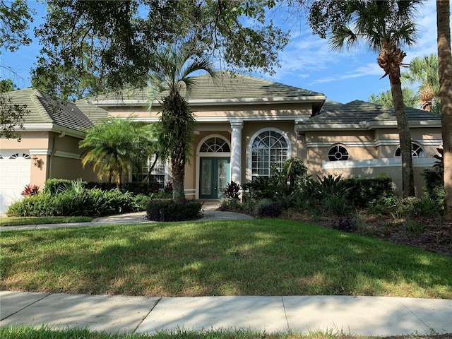 view of front of house featuring a front lawn and a garage