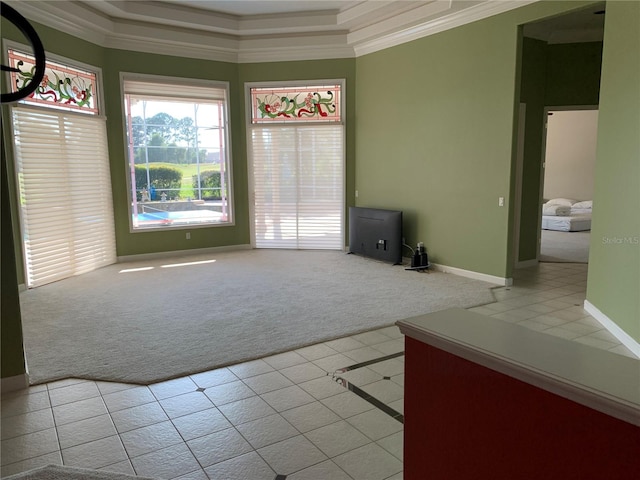 unfurnished living room with crown molding, a raised ceiling, and light tile patterned floors