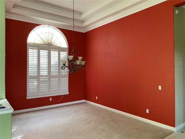 carpeted spare room with a raised ceiling, crown molding, and a chandelier