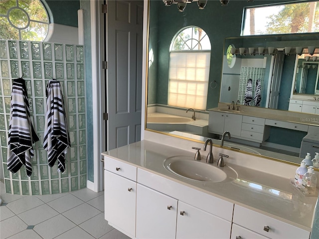 bathroom with tile patterned flooring, a bathtub, and vanity