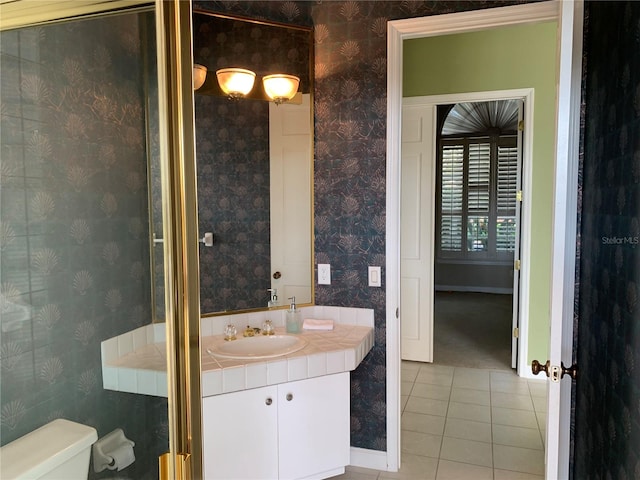 bathroom with toilet, vanity, and tile patterned floors