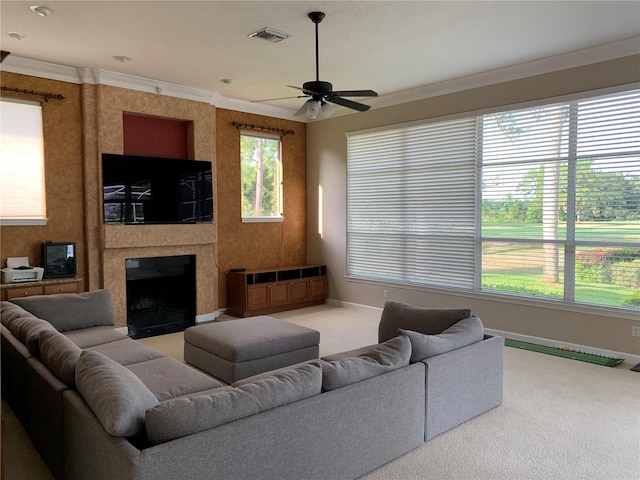 carpeted living room featuring ceiling fan, crown molding, and a premium fireplace