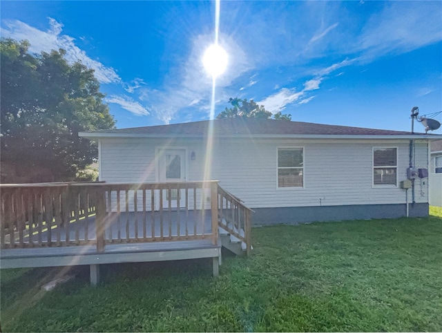 back of house featuring a deck and a yard