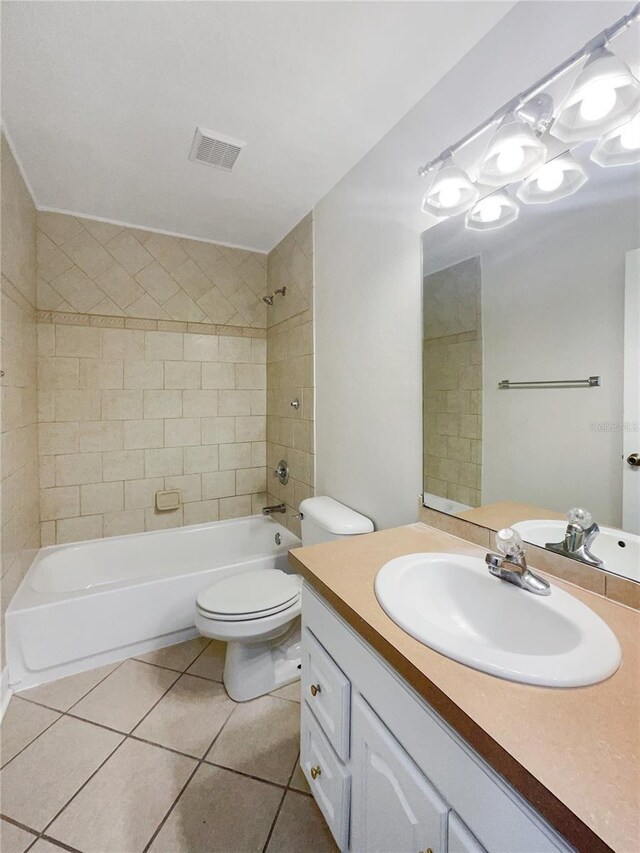 full bathroom with tile patterned flooring, vanity, tiled shower / bath combo, and toilet