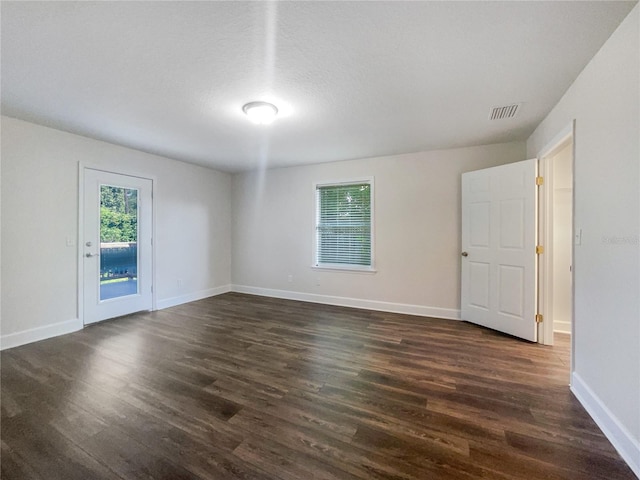 spare room featuring dark wood-type flooring