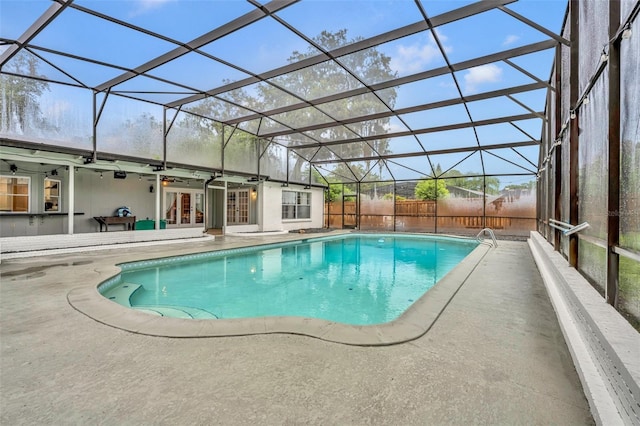 view of swimming pool featuring french doors, a patio, a lanai, and fence