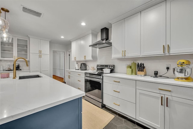 kitchen featuring a sink, visible vents, electric stove, wall chimney range hood, and light countertops