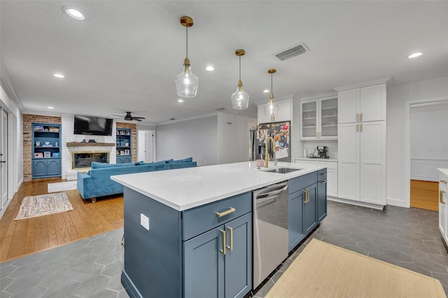 kitchen with a fireplace, visible vents, white cabinets, light countertops, and stainless steel dishwasher