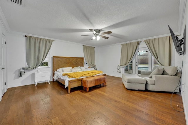 bedroom featuring visible vents, ceiling fan, hardwood / wood-style floors, crown molding, and a textured ceiling