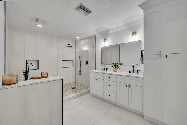 full bath featuring a textured ceiling, walk in shower, a sink, and visible vents