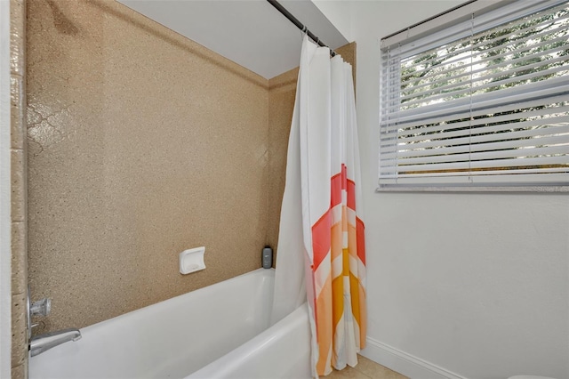 full bathroom with shower / bath combo and baseboards