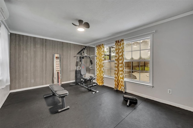 exercise area with a ceiling fan, baseboards, crown molding, and an AC wall unit