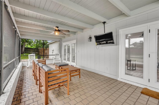 sunroom / solarium with a ceiling fan and beamed ceiling