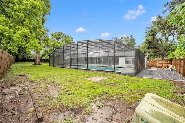 view of yard with a fenced in pool, glass enclosure, and a fenced backyard