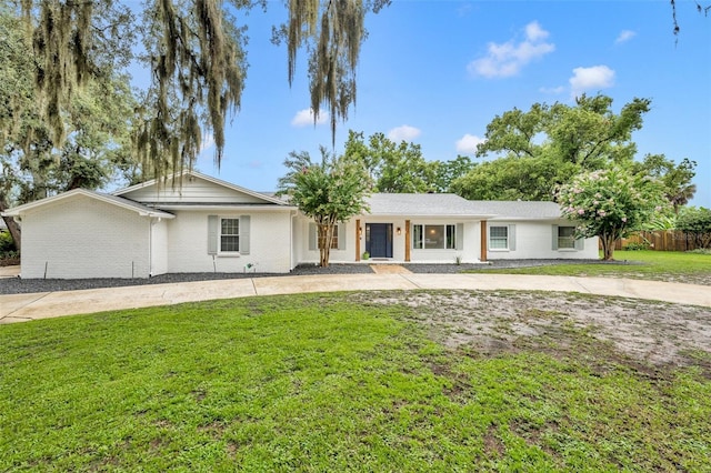 single story home with brick siding, fence, and a front lawn