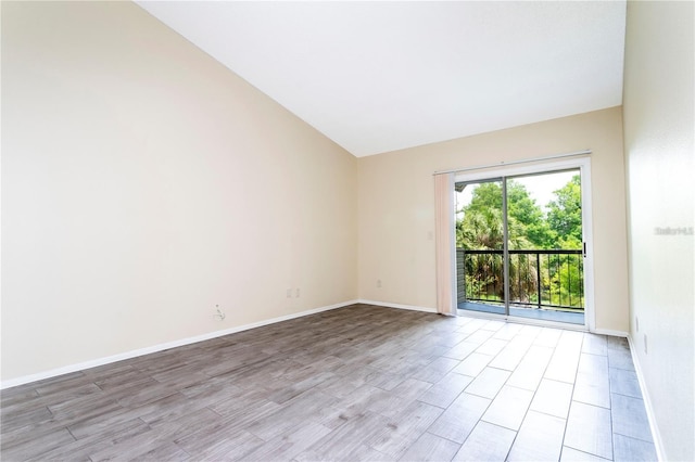 1932 Lake Atriums Cir Unit 86, Orlando, FL 32839 - empty room with baseboards, light wood finished floors, and vaulted ceiling