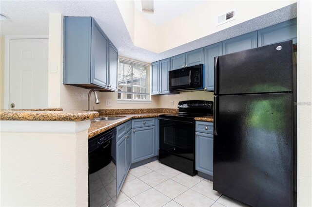 1932 Lake Atriums Cir Unit 86, Orlando, FL 32839 - kitchen featuring light tile patterned floors, visible vents, a sink, blue cabinetry, and black appliances