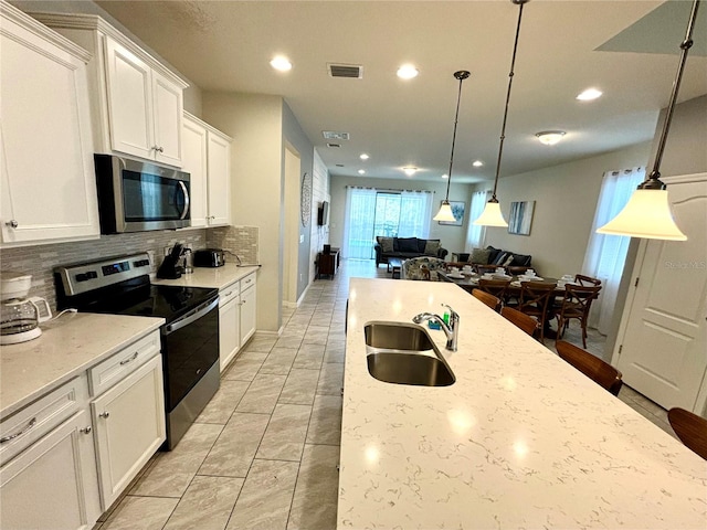 kitchen featuring appliances with stainless steel finishes, sink, light stone counters, and backsplash