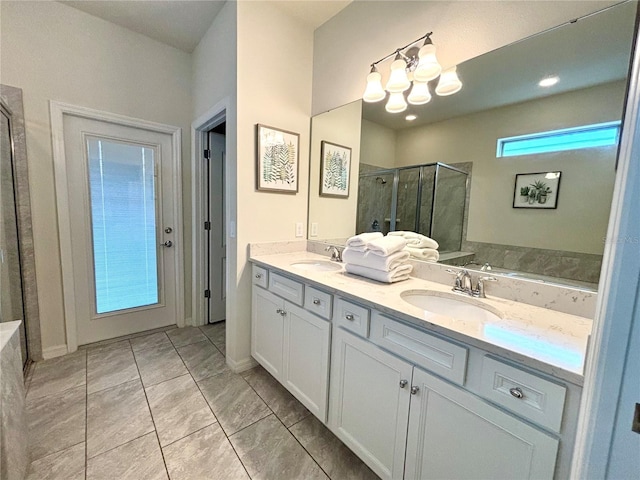 bathroom with double sink vanity, walk in shower, tile patterned floors, and a chandelier