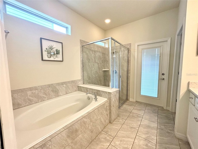 bathroom with tile patterned flooring, independent shower and bath, and vanity