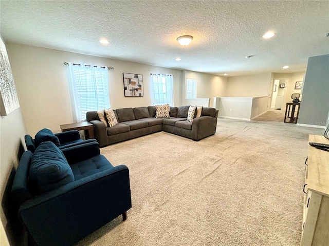 carpeted living room featuring a wealth of natural light and a textured ceiling