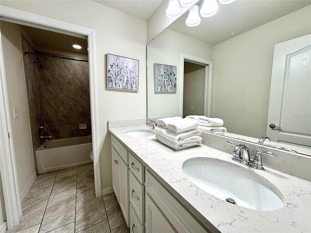 full bathroom featuring tiled shower / bath combo, toilet, dual bowl vanity, and tile patterned floors