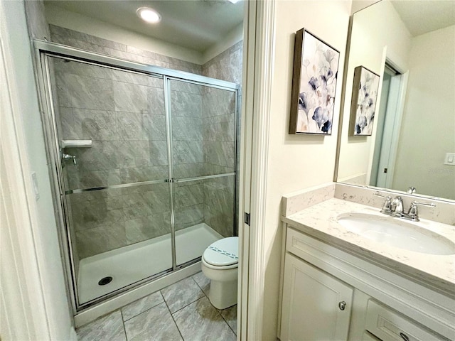 bathroom with tile patterned flooring, toilet, vanity, and a shower with shower door