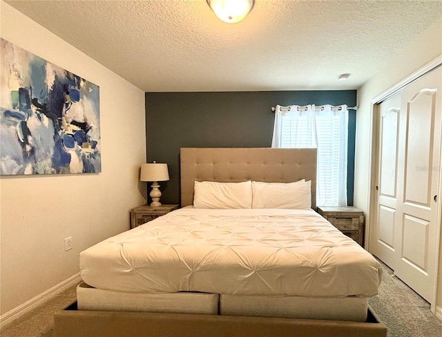 bedroom featuring a textured ceiling, carpet floors, and a closet