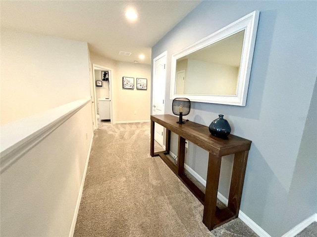 hallway featuring light colored carpet