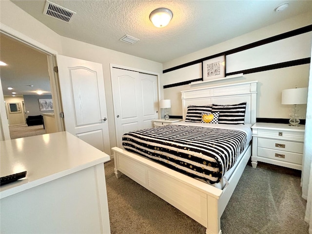 carpeted bedroom with a closet and a textured ceiling