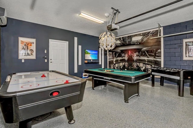 game room with a textured ceiling, pool table, and a wall unit AC