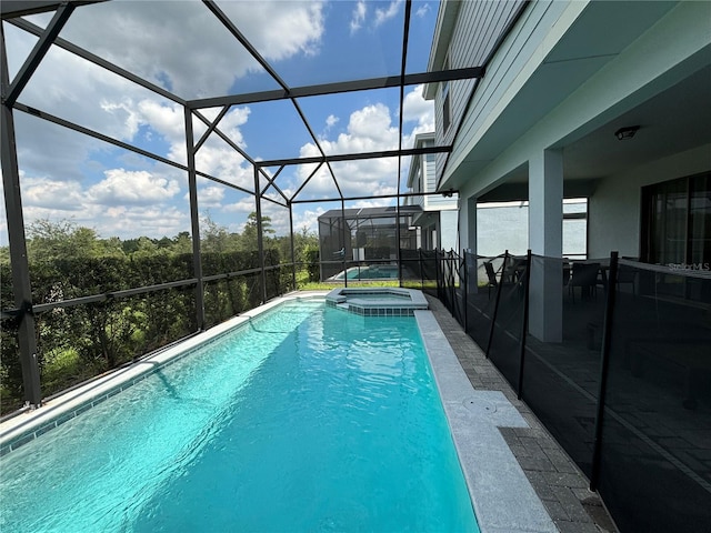 view of pool featuring an in ground hot tub, glass enclosure, and a patio area